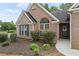 Close-up of the home's exterior, highlighting the brick facade, blue shutters, and landscaped garden at 7720 Paddocks Mill Dr, Cumming, GA 30041