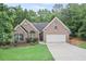 Traditional brick home with a well-kept lawn, attached garage, and welcoming curb appeal at 7720 Paddocks Mill Dr, Cumming, GA 30041