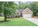 Charming brick home featuring a well-manicured lawn, mature trees, and a two-car garage at 7720 Paddocks Mill Dr, Cumming, GA 30041