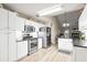 Modern kitchen featuring stainless steel appliances, white cabinetry, and access to the living room at 7720 Paddocks Mill Dr, Cumming, GA 30041