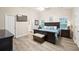 This large main bedroom features wood flooring, a king bed and a bench at the foot of the bed at 7720 Paddocks Mill Dr, Cumming, GA 30041