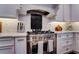 A stainless steel range with a decorative backsplash and stainless steel range hood at 1120 Bentwater Dr, Acworth, GA 30101
