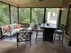 Relaxing screened-in porch with seating, dining area, string lights, and wooded view at 1120 Bentwater Dr, Acworth, GA 30101