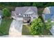 An aerial view of a home showing a well-manicured lawn, three-car garage, and mature trees at 139 Vinca Cir, Suwanee, GA 30024
