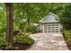 Light gray home with a garage and concrete driveway surrounded by lush landscaping at 2283 Pembrook Ne Pl, Atlanta, GA 30324