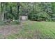 Spacious backyard featuring a storage shed surrounded by mature trees at 2538 Anchors Way, Snellville, GA 30078