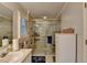 Bathroom featuring a glass shower with a seat, double sinks, and white cabinets at 2538 Anchors Way, Snellville, GA 30078