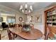 Elegant dining room featuring a chandelier, wood table with flowers and a display cabinet at 2538 Anchors Way, Snellville, GA 30078