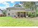 Rear exterior view of home with a screened-in porch and well-maintained lawn at 2538 Anchors Way, Snellville, GA 30078
