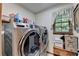 Bright laundry room with front loading washer/dryer and a storage bench at 2538 Anchors Way, Snellville, GA 30078