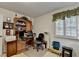 Well-lit office with wood desk, bookshelves, and window with blinds, ideal for a productive work environment at 2538 Anchors Way, Snellville, GA 30078
