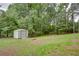 Spacious backyard with a shed, featuring lush trees and well-maintained grass at 3336 Forrest Hills Dr, Hapeville, GA 30354