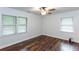 A bright bedroom featuring hardwood floors, a ceiling fan, and two windows at 3336 Forrest Hills Dr, Hapeville, GA 30354