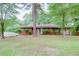 Traditional brick home featuring a blue entry door, mature trees, and a lush green lawn at 3336 Forrest Hills Dr, Hapeville, GA 30354