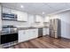 Modern kitchen with stainless steel appliances, white cabinets, granite countertops, and wood-look flooring at 3336 Forrest Hills Dr, Hapeville, GA 30354