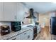 Elegant kitchen with gray cabinets, granite countertops, a stainless range hood, and wood floors at 3336 Forrest Hills Dr, Hapeville, GA 30354