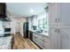 Stylish kitchen featuring gray cabinetry, granite countertops, stainless appliances, and wood flooring at 3336 Forrest Hills Dr, Hapeville, GA 30354