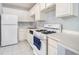 Well-lit kitchen featuring white appliances and cabinets with a stainless steel faucet at 620 Peachtree Ne St # 1001, Atlanta, GA 30308
