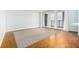 Spacious living room with wood floors, large windows with white drapes, and a neutral rug at 620 Peachtree Ne St # 1001, Atlanta, GA 30308