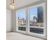 Bedroom featuring large windows with city views and modern light fixtures, creating a bright and inviting space at 867 Peachtree Ne St # 702, Atlanta, GA 30308