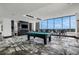 Bright game room features a billiards table, bar stool seating, and expansive windows with beautiful outdoor views at 867 Peachtree Ne St # 702, Atlanta, GA 30308