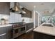 Contemporary kitchen with stainless steel stove and hood over white tile backsplash at 867 Peachtree Ne St # 702, Atlanta, GA 30308