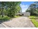A modest one-story home with a long driveway and attached garage nestled among mature trees and greenery at 1799 Harmony Rd, Powder Springs, GA 30127