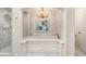 Stylish bathroom featuring a tub with marble surround, a chandelier, and a glass-enclosed shower at 3089 Marne Nw Dr, Atlanta, GA 30305