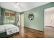 Bright green bedroom with hardwood floors, natural light, and access to a hallway and closet at 3089 Marne Nw Dr, Atlanta, GA 30305