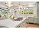 Kitchen with gas cooktop on island, farmhouse sink, large windows, and sage-colored cabinets at 3089 Marne Nw Dr, Atlanta, GA 30305