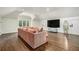 Bright living room with hardwood floors, big screen tv and a comfortable oversized pink couch at 3089 Marne Nw Dr, Atlanta, GA 30305