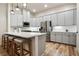 Modern kitchen featuring white cabinets, stainless steel appliances, and a spacious island with seating at 800 Old Plank Sq, Duluth, GA 30097