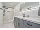 Modern bathroom featuring a white and grey marble shower, grey vanity, and lighted mirror at 2026 Patterson Park Pl, Lawrenceville, GA 30044