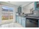 Open kitchen with blue cabinets, stainless steel appliances, and sliding glass doors leading to the backyard at 2026 Patterson Park Pl, Lawrenceville, GA 30044