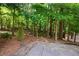 Secluded backyard with mature trees, a stone patio and path leading to wooded areas at 2360 Whispering Nw Dr, Kennesaw, GA 30144