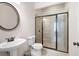 Modern bathroom featuring a glass-enclosed shower, pedestal sink, and stylish fixtures at 2360 Whispering Nw Dr, Kennesaw, GA 30144