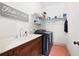 Practical laundry room featuring a sink, storage shelves, and modern washer and dryer at 2360 Whispering Nw Dr, Kennesaw, GA 30144