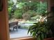 A lovely backyard view with a small pond and lush greenery viewed through a window at 4098 Nancy Creek Ne Way, Brookhaven, GA 30319