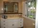 Well-lit bathroom featuring marble walls, white vanity, and a large window for natural light at 4098 Nancy Creek Ne Way, Brookhaven, GA 30319