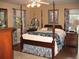 Traditional bedroom with a dark wood four-poster bed, hardwood floors, and floral curtains at 4098 Nancy Creek Ne Way, Brookhaven, GA 30319