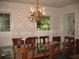 Dining room with floral wallpaper, a chandelier, and a large glass-top table with wooden chairs at 4098 Nancy Creek Ne Way, Brookhaven, GA 30319