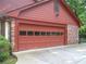 Attached two-car garage with red door and side brick detail at 4098 Nancy Creek Ne Way, Brookhaven, GA 30319