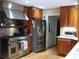 Stainless steel refrigerator and range hood in kitchen featuring wood cabinets and light hardwood floors at 4098 Nancy Creek Ne Way, Brookhaven, GA 30319