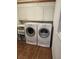 Neat laundry room featuring a front load washer and dryer, wood flooring, and upper cabinets for storage at 4098 Nancy Creek Ne Way, Brookhaven, GA 30319