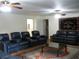 Spacious living room featuring neutral walls, ceiling fans, and black leather furniture set with a patterned rug at 4098 Nancy Creek Ne Way, Brookhaven, GA 30319