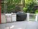 Outdoor kitchen with built-in grill, stone accents, and white railing at 4098 Nancy Creek Ne Way, Brookhaven, GA 30319