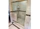 Bathroom with a glass enclosed shower stall, with neutral tiling and brass trim at 4098 Nancy Creek Ne Way, Brookhaven, GA 30319
