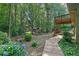 Lush backyard featuring a bridge, walking path and a distant playset, perfect for outdoor activities at 680 Spirit Falls Way, Johns Creek, GA 30022