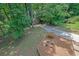 Landscaped backyard featuring lush green foliage and a concrete drive for additional parking at 680 Spirit Falls Way, Johns Creek, GA 30022