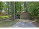 Spacious backyard featuring a shed and a concrete area near a chain-link fence and mature trees at 680 Spirit Falls Way, Johns Creek, GA 30022